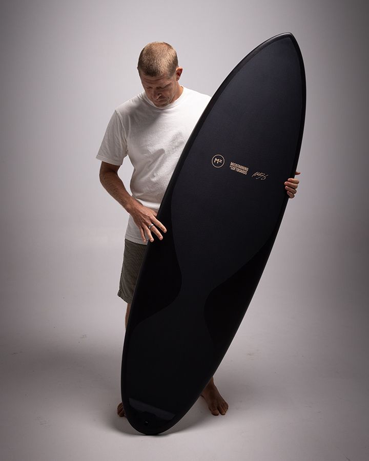 Mick Fanning holding a black Mick Fanning Softboard